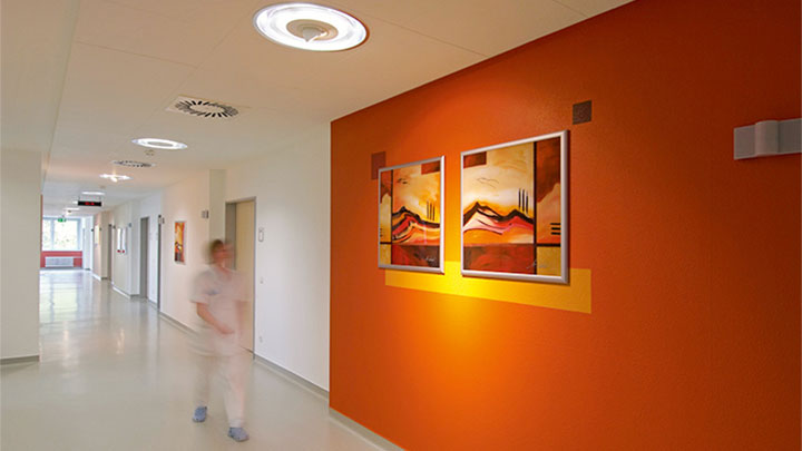 Nurse is walking in a lit corridor by Philips at the psychiatric clinic