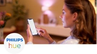Woman controlling the lights in her living rooms with her smartphone
