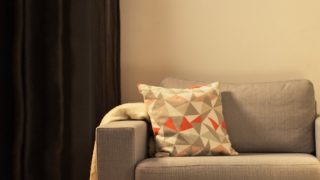 "Cozy living room with modern LED table lamp, illuminating gray loveseat and creating warm ambiance for home relaxation."