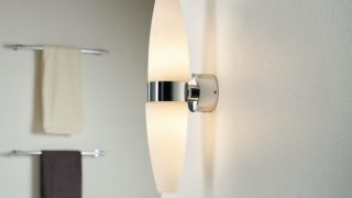 Modern bathroom featuring sleek LED wall sconce, illuminating minimalist decor and enhancing spa-like ambiance.