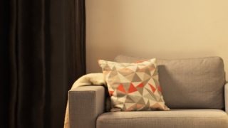 舒適的客廳配有現代 LED 檯燈，照亮灰色雙人沙發，營造出家庭放鬆的溫馨氛圍。