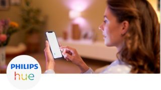 女人在客廳用智慧型手機控制燈光
