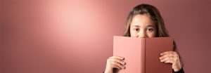 “年輕女孩在柔和的 LED 照明背景下瞥見粉紅色的書，展現出溫暖、均勻的照明，營造出舒適的閱讀環境。”
